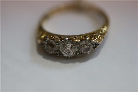 An Edwardian 18ct gold and graduated three stone diamond ring, size O.